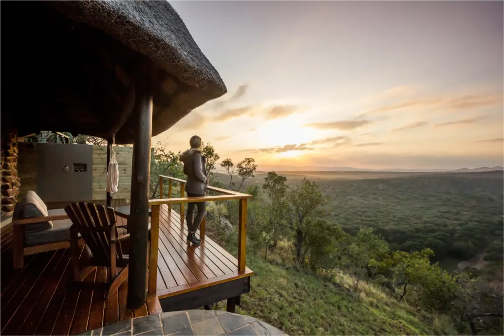 Guest on a lodge deck overlooking the bush during a luxury biohacking retreat at Leopard Mountain