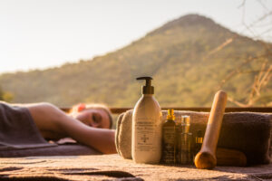 Africology spa products laid out on a treatment table with mountain views in the background